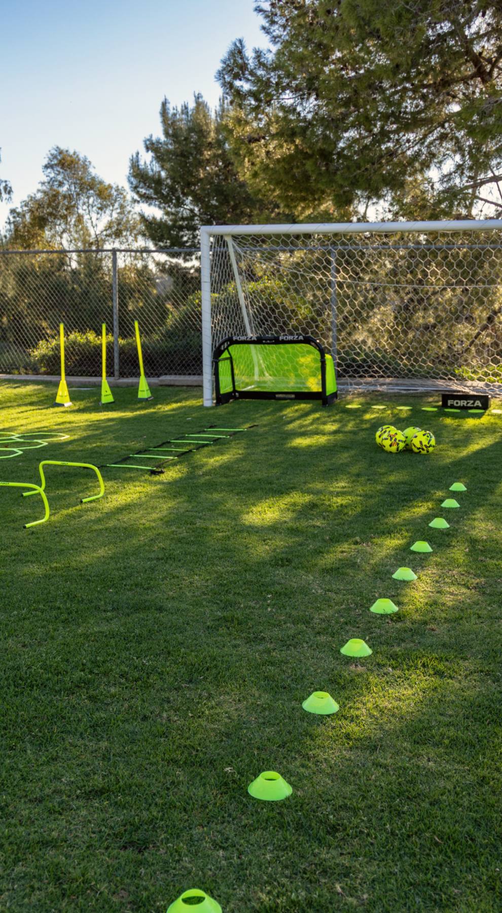 The Soccer Lab's full training setup at golden hour in Carlsbad, goals, hurdles, rings and a cone line ready for a group